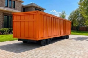 large orange roll off dumpster is parked on paved driveway in front of modern brick house