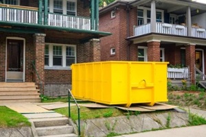 yellow dumpster outside a home going through renovation