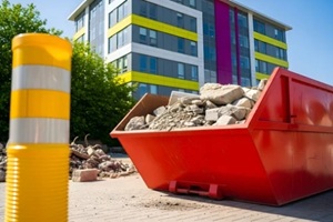 waste management services for commercial building demolition  Yellow flexible barrier pole at urban development site 