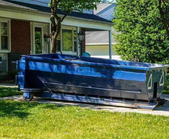 blue dumpster in the driveway of a house in a residential neighborhood - city of chesapeake bulk pickup