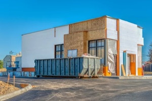 blue pickup dumpster outside a newly built store