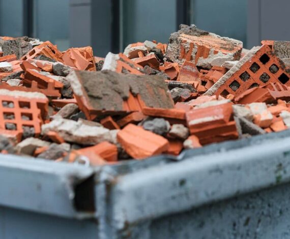 red bricks debris in construction metal waste container close up