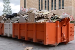 huge heap on metal Big Overloaded dumpster waste container filled with construction waste
