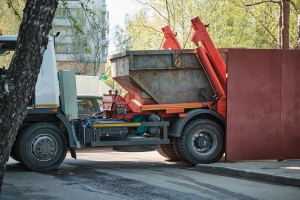 Garbage Truck Loading Metal Container with Bulk Trash and Construction Waste