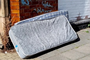 two old mattresses abandoned on a city pavement