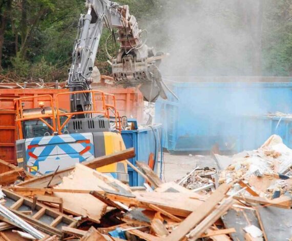 construction site with heavy machinery working on debris removal in a city area during daytime hours