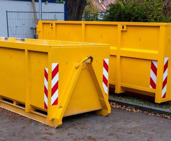 yellow metal dumpster containers for construction garbage, house renovation, building of residential apartments