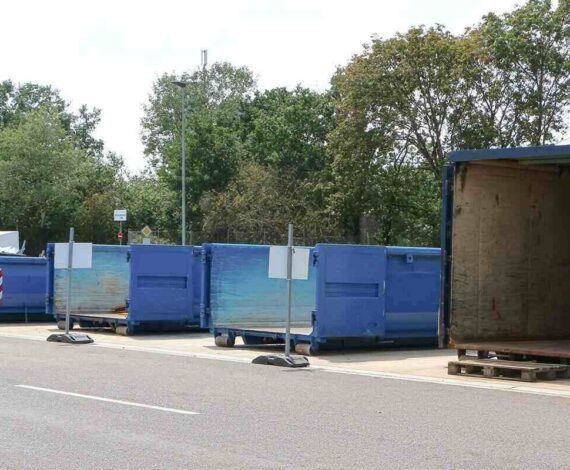 various size dumpsters parked near the road