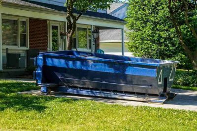 blue dumpster in the driveway of a house in a residential neighborhood - city of chesapeake bulk pickup
