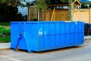 blue roll-off construction dumpster rental outside a seasonal property