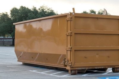 dumpster rental industrial bin in commercial parking lot site brown trash removal skip