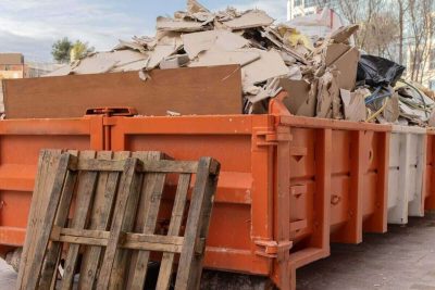 huge heap on metal big overloaded dumpster waste container filled with construction waste