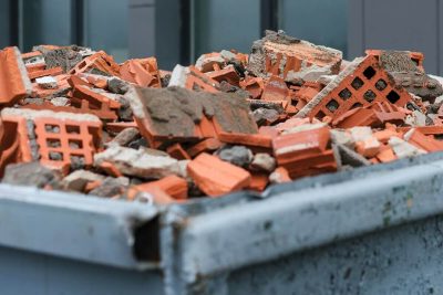 red bricks debris in construction metal waste container close up