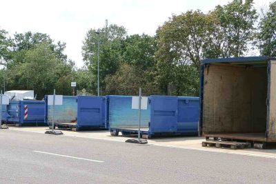 various size dumpsters parked near the road