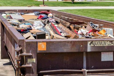 waste dumpster full of household junk