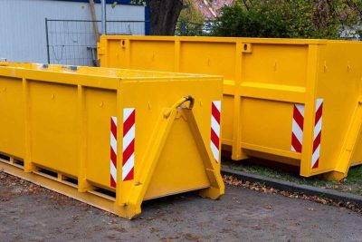 yellow metal dumpster containers for construction garbage, house renovation, building of residential apartments
